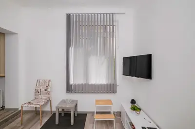 a living room with a tv on a white wall at Central 1BD Next to Womens Market and Sofia's Gems by Flat Mаnаger in Sofia