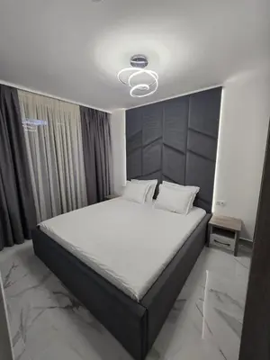 a bedroom with a large bed with a white bedspread at Center Park Apartment in Sandanski