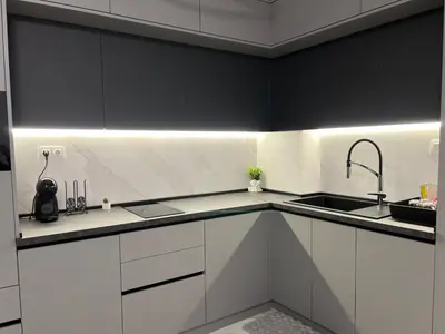 a kitchen with black and white cabinets and a sink at Center Park Apartment in Sandanski