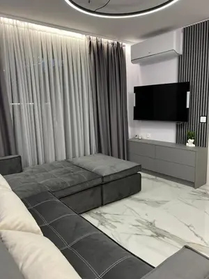 a living room with a couch and a flat screen tv at Center Park Apartment in Sandanski