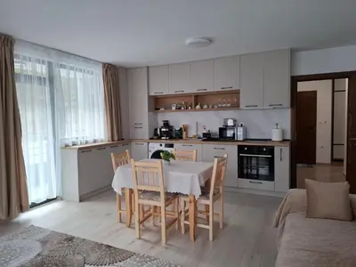 a kitchen and dining room with a table and chairs at Апартамент Дерменджиев in Sandanski