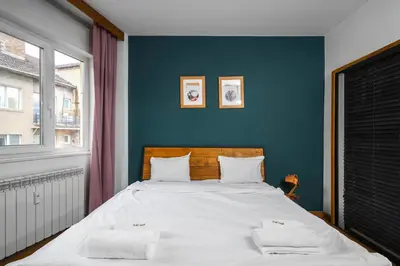 a bedroom with a large bed with a blue wall at Central Sanctuary 3BD by Flat Mаnаger in Sofia