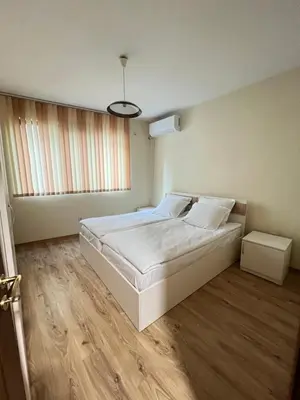 a bedroom with a large white bed and wooden floors at Victoria apartment - Sandanski in Sandanski