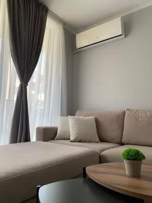a living room with a couch and a window at Tanov Cozy Place in Blagoevgrad