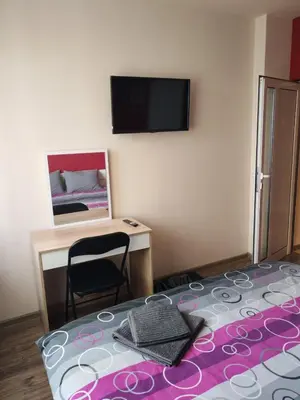 a room with a bed and a desk and a television at Heart of Pernik apartment 2 in Pernik