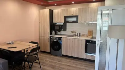 a kitchen with a table and a microwave and a stove at Heart of Pernik apartment 2 in Pernik