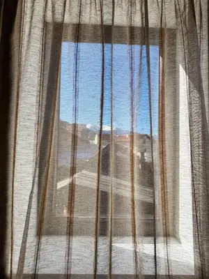 a view of a desert from a window with curtains at Хотел Добринище in Dobrinishte