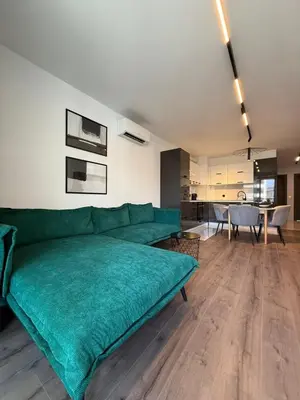 a living room with a green couch and a dining room at DomBox Sofia Suites - Stylish 2 Bedroom in Center - Free Garage in Sofia