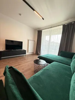 a living room with two green couches and a flat screen tv at DomBox Sofia Suites - Stylish 2 Bedroom in Center - Free Garage in Sofia