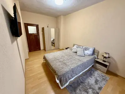a bedroom with a bed and a flat screen tv at Guest House Mihalkovo in Mikhalkovo