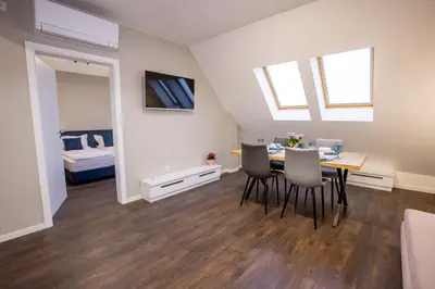 a dining room with a table and chairs and a bedroom at Saphi Apt in Sandanski