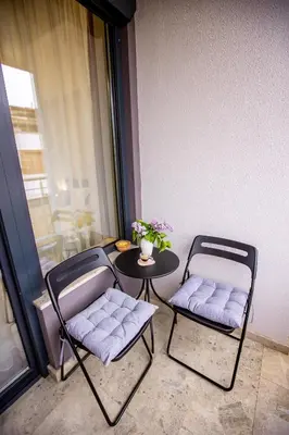 two chairs and a table in a room with a window at Saphi Apt in Sandanski
