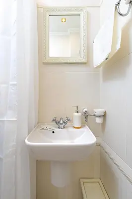 a white bathroom with a sink and a mirror at 1BR Apartment in the Center with Free Street Parking and Designated Workspace in Plovdiv