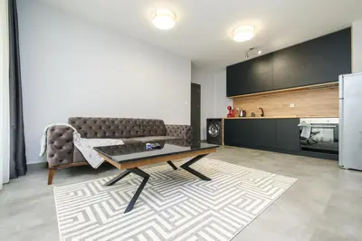 a living room with a couch and a table and a kitchen at Quiet & Comfy 1BR in the Heart of Plovdiv with Private Balcony in Plovdiv