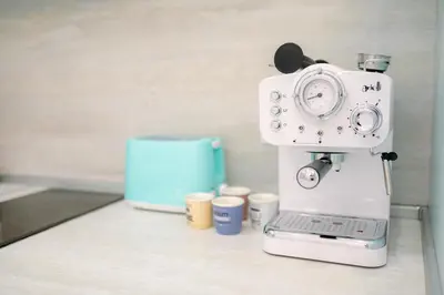a white espresso machine sitting on a counter with cups at Top Center - 2 min from NDK in Sofia