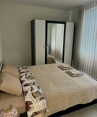 a bedroom with a large bed with a mirror at Cozy Home 2 Bedroom apartment in Kyustendil
