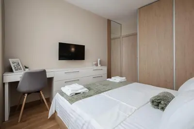 a bedroom with a bed and a desk with a television at Brand New Luxury Apartments with Great Views in Sofia