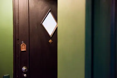 a wooden door with a small window on it at Wonderland Rooms for Rent in Sofia