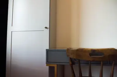 a desk with a chair next to a white door at Wonderland Rooms for Rent in Sofia