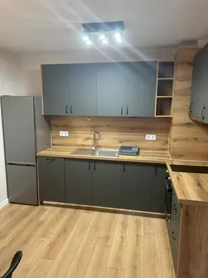 a kitchen with gray cabinets and a wooden counter top at Cozy and comfortable panorama park Entrance E not K in Plovdiv