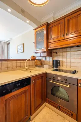 a kitchen with wooden cabinets and a dishwasher at Elegant Aristocratic 2 BDRM Flat, TOP Location in Sofia