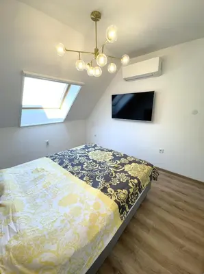a bedroom with a bed and a chandelier at Cozy Home In Central Plovdiv in Plovdiv