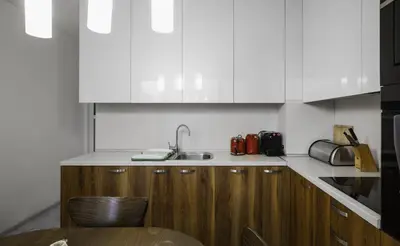 a kitchen with white cabinets and a sink and a table at The Cosmopolitan Shine 1-BDR Pet-Friendly Flat in Sofia