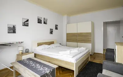a white bedroom with a bed and a chair at The Cosmopolitan Shine 1-BDR Pet-Friendly Flat in Sofia