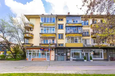 a tall yellow building with a bench in front of it at Serene Living in the Heart of Plovdiv by Flat Mаnager in Plovdiv
