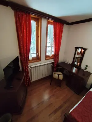 a room with a television and a desk and windows at Mountain View ECOVILLA in Devin