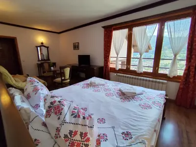 a bedroom with a bed and a large window at Mountain View ECOVILLA in Devin