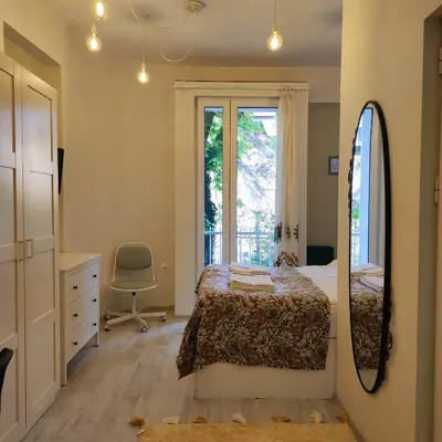 a bedroom with a bed and a mirror and a window at NDK Central Home in Sofia