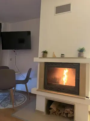 a fireplace in a living room with a fire in it at Nest by the Peaks Apartment in Bansko in Bansko