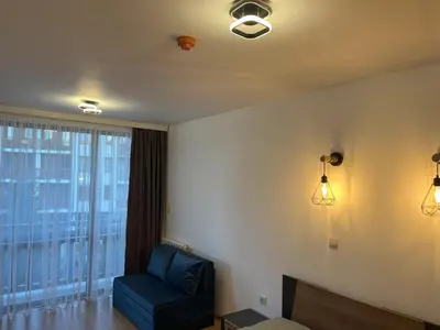 a living room with a blue chair and a window at Nest by the Peaks Apartment in Bansko in Bansko