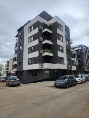 a large building with cars parked in a parking lot at luxury Apartament TD one bedroom in Sofia