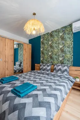 a bedroom with a large bed with blue walls at Exotic apartment in Sofia
