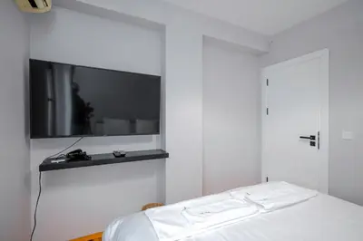 a bedroom with a bed with a tv on the wall at AeroLuxe Living 1BD Apartment by Flat Mаnager in Sofia