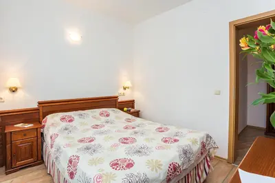 a bedroom with a bed with a floral bedspread at Fantastic 1-bedroom apartment Stream Resort in Pamporovo