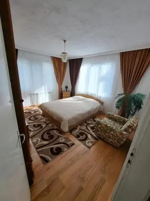 a bedroom with a bed and a chair in a room at Къща за гости ЖАНИ in Zmeitsa