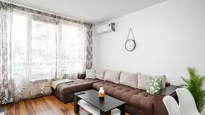 a living room with a brown couch and a table at Terra Vibes - Central 1BD with balcony by Flat Mаnager in Sofia