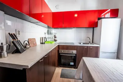 a kitchen with red cabinets and a counter top at Salts Market 3BR Retreat in Sofia