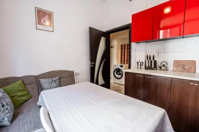 a kitchen with red cabinets and a bed in a room at Salts Market 3BR Retreat in Sofia