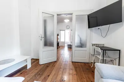 a white living room with a kitchen and a table at Salts Market 3BR Retreat in Sofia