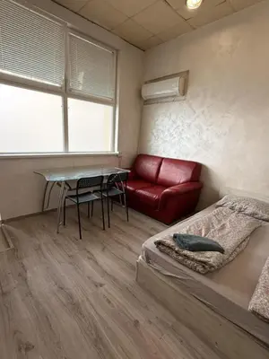a room with a bed and a table and a couch at The Alpha in Sofia