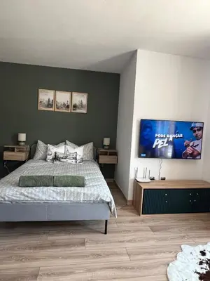 a bedroom with a bed and a tv on the wall at Bansko Gondola Apart in Bansko