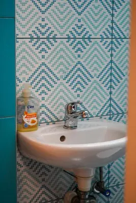 a sink in a bathroom with a blue and white tiled wall at Top-View Terrace 2BD Central Apt in Sofia