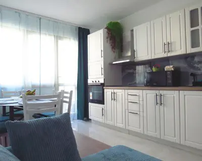 a kitchen with white cabinets and a table and chairs at Полименови in Sofia