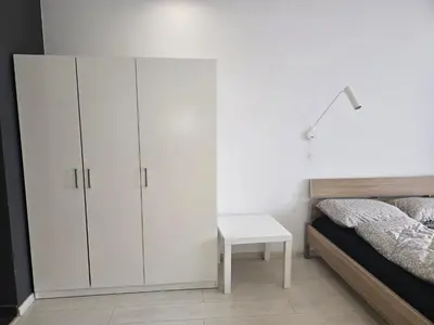 a bedroom with white cabinets and a bed and a table at The Peak in Sofia