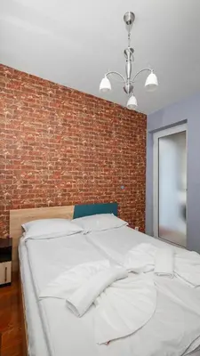 a bedroom with a brick wall and a white bed at Central Cozy 1BD Compact Chic Living by Flat Mаnager in Sofia