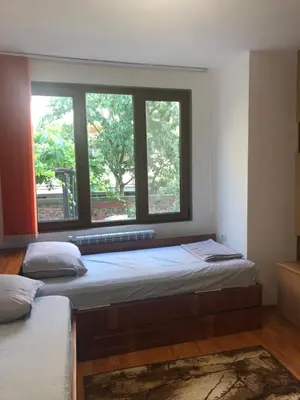 two beds in a room with two windows at При Бети in Sandanski